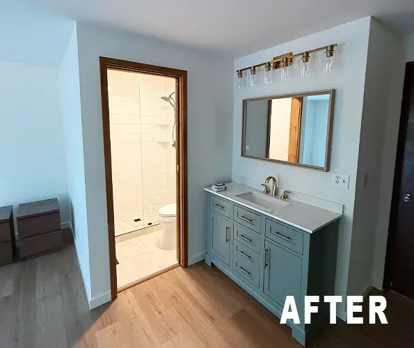 Bathroom after remodel with blue vanity, framed mirror and plank flooring