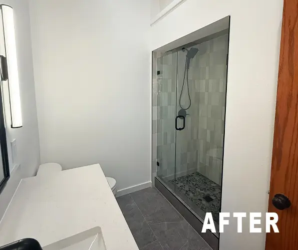 Bathroom after remodel with tiled walk-in shower and frameless glass