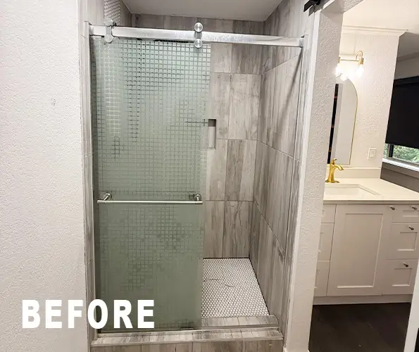 Bathroom before remodel with frosted glass shower and beige tile